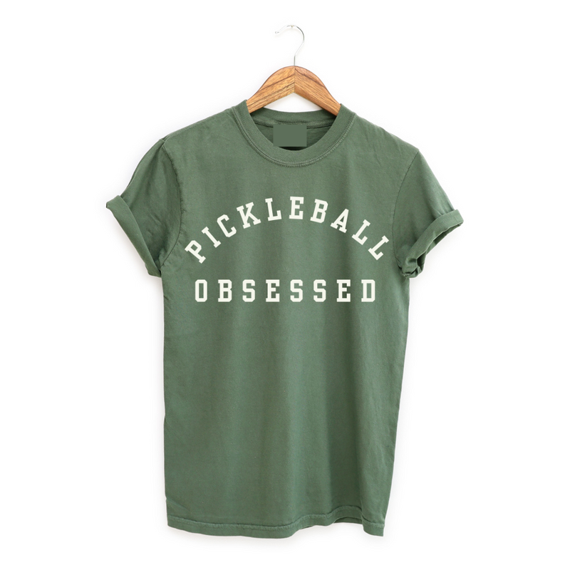 Show your pickleball passion with our Pickleball Obsessed tee! Crafted with impeccable quality. Classic colors.  This tee runs true to size but size up for that effortlessly relaxed fit. Perfect for dominating the courts or adding a dash of pickleball flair to your everyday style. Get ready for your new favorite tee that screams obsession, comfort, and unmistakable pickleball pride!