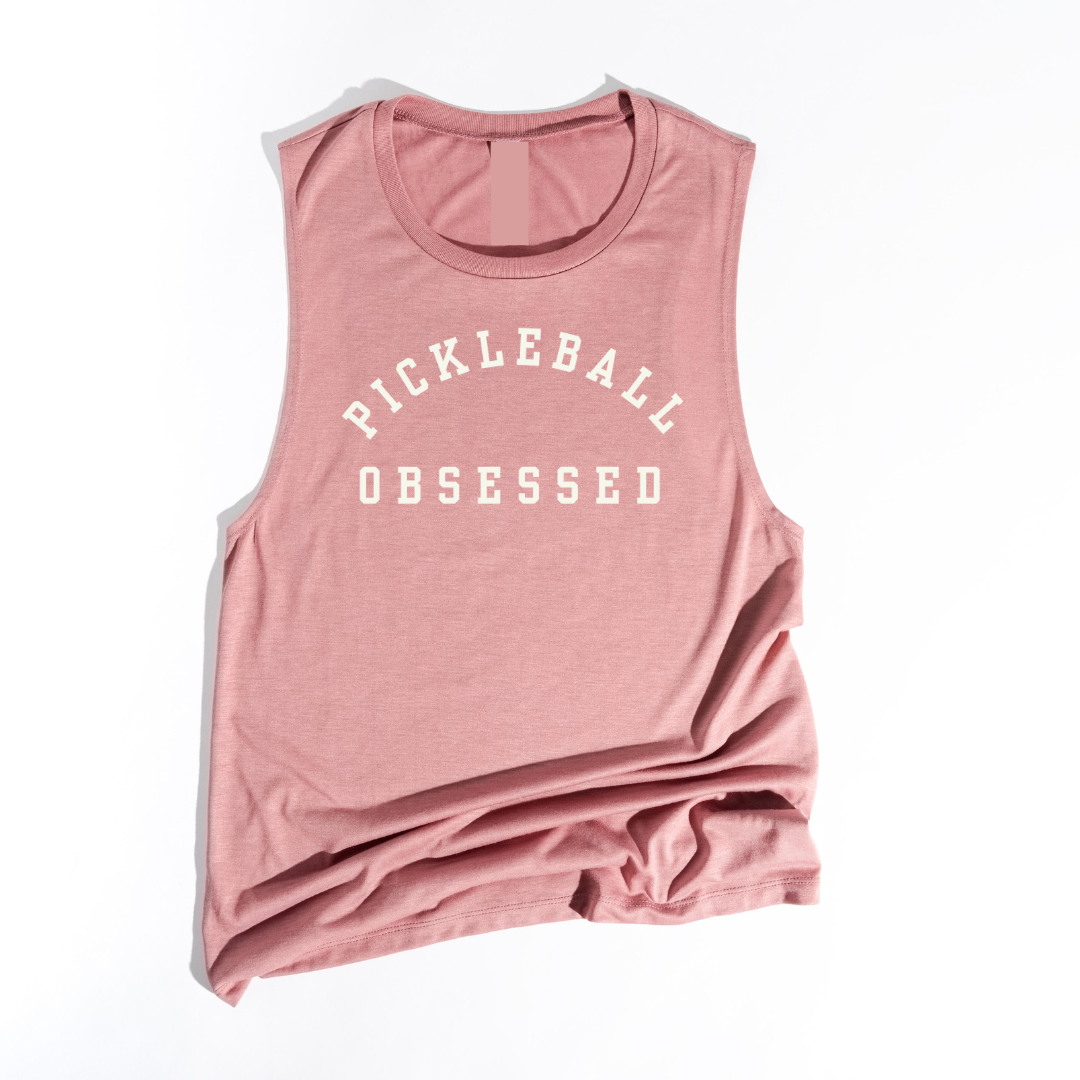 Show your pickleball passion with our Pickleball Obsessed tank top! Crafted with impeccable quality and offered in a variety of colors.  You'll love how this tank works for dominating the courts or adding a dash of pickleball flair to your everyday style. Wear alone of layer with your favorite jacket! Get ready for your new favorite tank- one that screams obsession, comfort, and unmistakable pickleball pride!