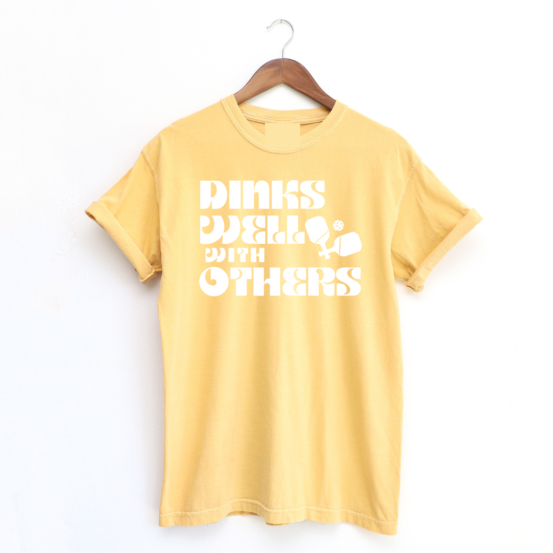 Indulge in the art of the dink with our "Dinks Well With Others" Tee! This shirt radiates playful charm and unmatched comfort, making it your go-to on and off the courts. Showcase your love for pickleball and your witty side in this statement piece that's sure to spark conversations and turn heads. Dink well, and do it in style! 