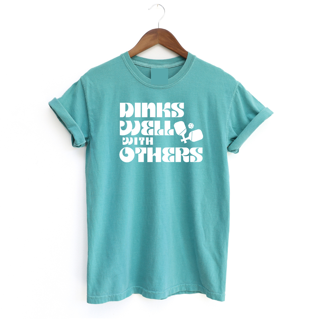 Indulge in the art of the dink with our "Dinks Well With Others" Tee! This shirt radiates playful charm and unmatched comfort, making it your go-to on and off the courts. Showcase your love for pickleball and your witty side in this statement piece that's sure to spark conversations and turn heads. Dink well, and do it in style! 