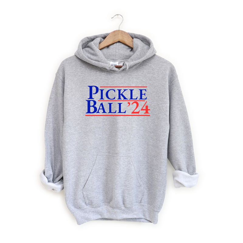 Introducing our EXCLUSIVE “PickleBall ‘24”Hoodie – because who says politics can’t be a dill-lightful game?  Embrace the ultimate combo of PickleBall ‘24 and the upcoming 2024 Election!! Wear it proudly and let everyone know you’re on #TeamPickle. PickleBall ‘24 is the pickle-fied fashion statement that’s both baller and bipartisan!  *Also available in tees, tanks, sweatshirts & trucker hats- for guys and gals!! 