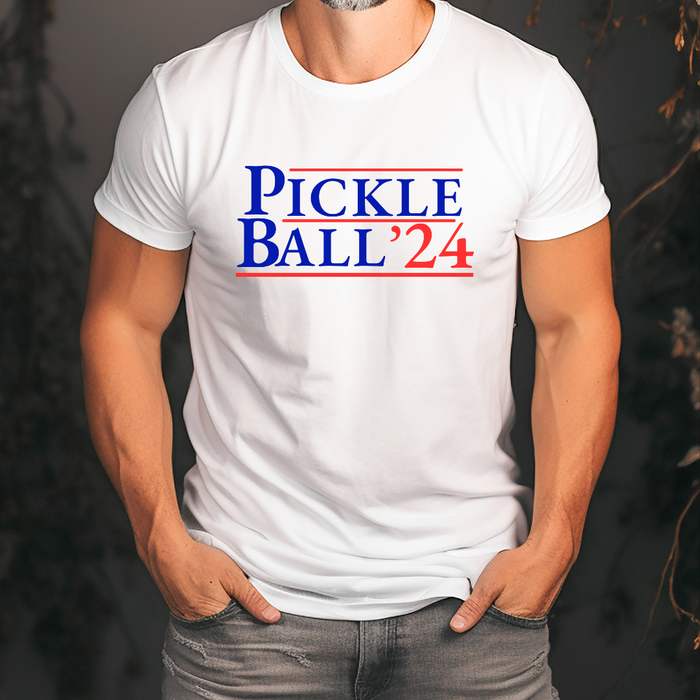 Introducing our EXCLUSIVE “PickleBall ‘24” Men’s t-shirt – because who says politics can’t be a dill-lightful game?  Embrace the ultimate combo of PickleBall ‘24 and the upcoming 2024 Election!! Wear it all proudly and let everyone know you’re on #TeamPickle. PickleBall ‘24 is the pickle-fied fashion statement that’s both baller and bipartisan!  *Also available in tanks, hoodies, sweatshirts & trucker hats- for guys and gals!! 