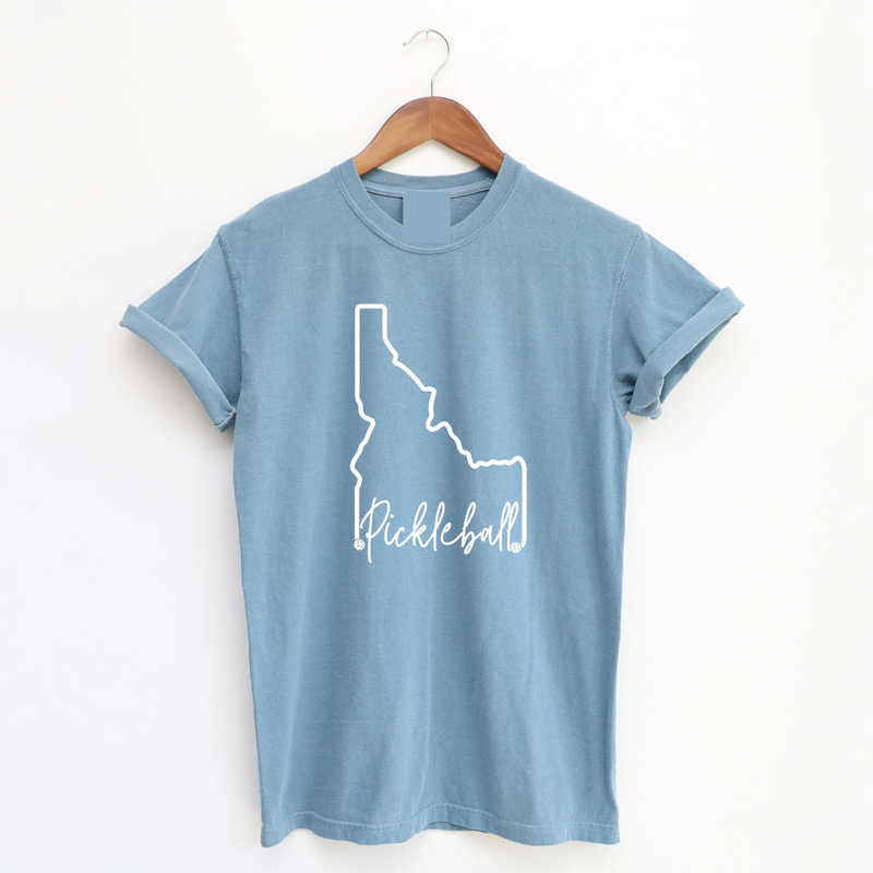 Elevate your style and showcase your love for both the Gem State and pickleball with our Pigment Dyed Idaho Pickleball t-shirt!  Crafted with care, this tee is more than just an article of clothing; it's a statement of pride and passion. 