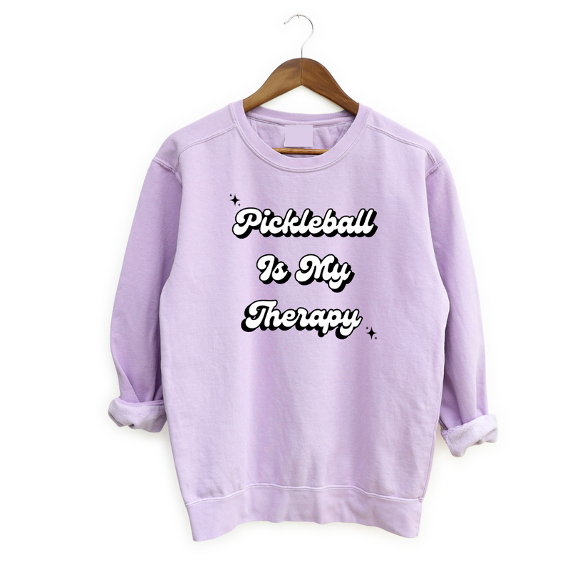 Introducing the latest gem in the PickleChicks apparel line: the "Pickleball Is My Therapy" Sweatshirt. This isn't just any sweatshirt, it's a statement, a testament to the transformative power of pickleball in our lives.