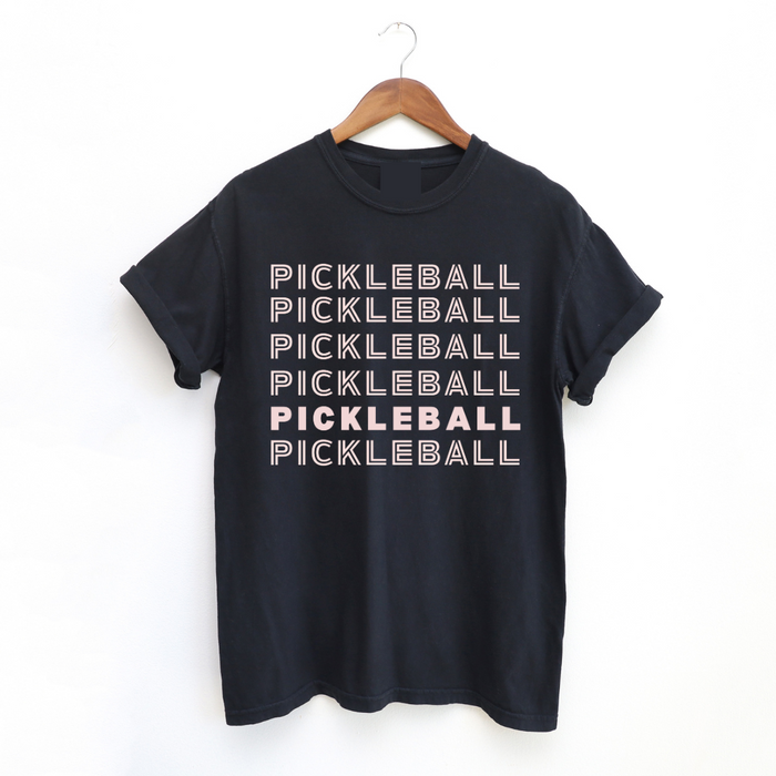 Rock this Pickleball On Repeat Tee everywhere you go! It's super comfy, cute and is great on the courts or off as you do life! Black tee with pink lettering for the win!  Relaxed fit, seamless body. Unisex sizing. See Chart Below.   Garment dyed for that lived in feel and almost no shrinkage at home  Soft ring spun cotton fabric with 100% cotton threads! 
